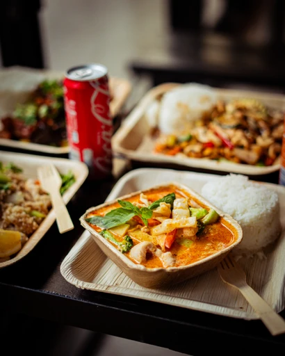 Uppdukade wokrätter i takeaway-boxar med ris och sallad