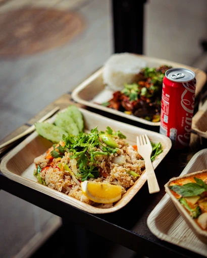 Flera takeaway-boxar med wokrätter, ris och sallad uppdukade